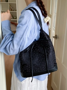 Chic black polka dot bucket bag with bow detail and leather straps for casual wear