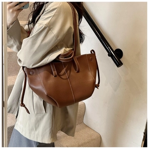 Brown lychee grain leather tote bag with white stitching detail shown on shoulder