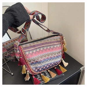 Detail of colorful woven bohemian bag showing vibrant patterns and tassel charms