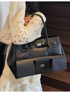 Large black matte leather tote bag with dual handles and turn-lock on a model