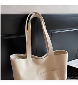 Close-up of cream canvas tote bag featuring double handles and functional front pocket