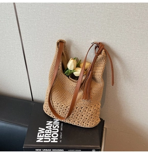 Detail of hand-woven beige tote bag with leather strap, tassels and decorative tulips