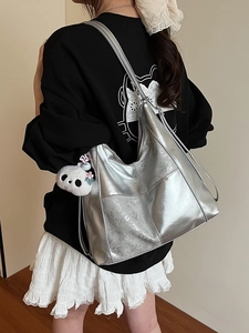 Grand sac cabas argenté métallisé avec breloque panda porté par un mannequin