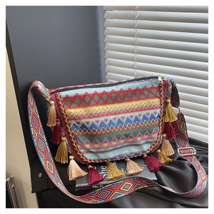 Close-up of bohemian woven crossbody bag with colorful tassels and geometric patterns