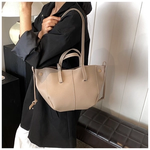 Detail of khaki lychee grain leather tote bag with side drawstring and slim shoulder straps