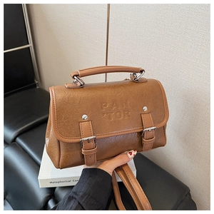 Details der braunen Vintage-Ledertasche mit PAN TOR-Prägung und Schnallenriemen