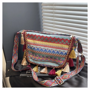Detail of bohemian embroidery and colorful tassels on an ethnic crossbody bag