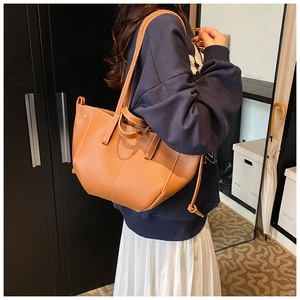 Detail of brown litchi pattern faux leather tote bag with stylish side drawstring design