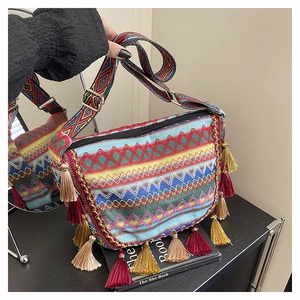 Close-up of bohemian crossbody bag with colorful woven patterns and tassel details