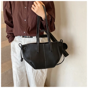 Detail of black leather tote bag with white contrast stitching and side drawstrings