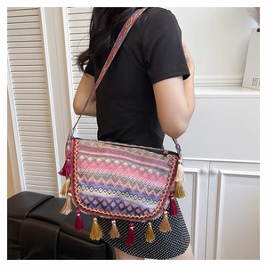 Close-up of bohemian woven bag with colorful geometric patterns and long tassel fringe