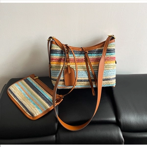 Detail of colorful striped straw tote bag and matching pouch with brown leather straps