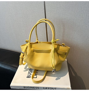 Detail of yellow lychee grain leather bucket bag with metal ring and drawstring strap
