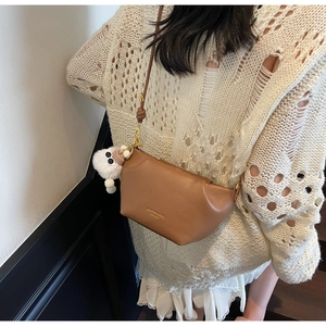Sac demi-lune en similicuir marron avec breloque petit monstre en peluche blanc