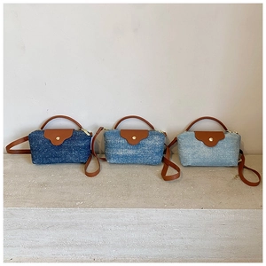 Three denim crossbody bags in blue shades with brown leather flaps and gold buckles