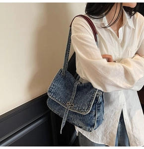 Détail du sac à bandoulière en denim délavé rétro avec boucle en métal et texture denim