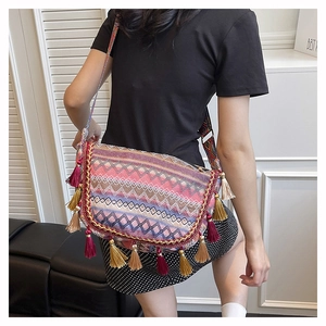 Detail of bohemian woven bag with colorful jacquard fabric and vibrant fringe accents