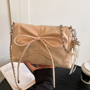 Beige ballet style shoulder bag with oversized bow and silver chain strap for women