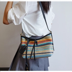 Detail of bohemian rainbow striped woven bag with black leather tassel and crossbody strap