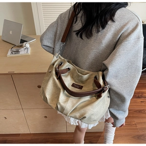 Dettaglio di una borsa tote in tela beige con spalline in pelle marrone per il pendolare