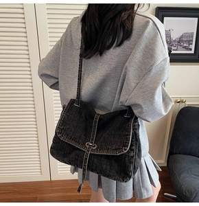 Gros plan d'un sac cabas vintage en denim noir avec boucle argentée porté