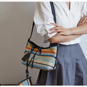 Detail of colorful woven straw shoulder bag with black leather trim and matching pouch