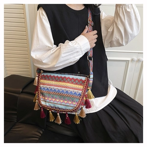 Detail of bohemian woven crossbody bag featuring colorful geometric patterns and tassels