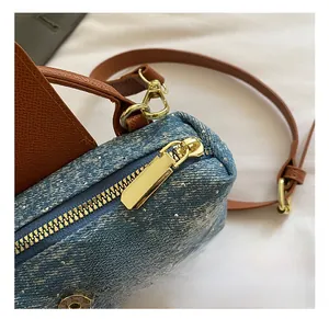 Detailed close-up of blue denim bag with sparkling rhinestones and golden metal hardware