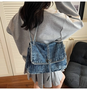 Vue détaillée du tissu en jean vintage avec boucle en métal et finitions de couture doubles