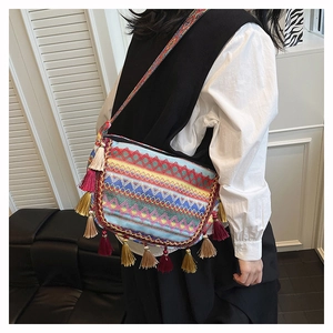 Close-up of bohemian shoulder bag featuring colorful ethnic embroidery and long tassel details
