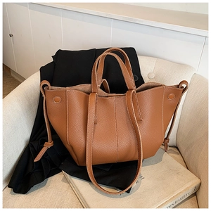Detail of brown litchi pattern leather tote bag with side drawstring and hardware rivets