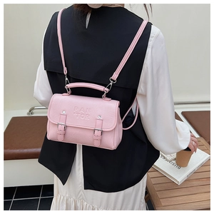 Pink faux leather bag detail showing PAN TOR embossed logo and silver metallic buckle