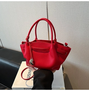 Detail of red lychee pattern leather bucket bag with silver crescent moon charm