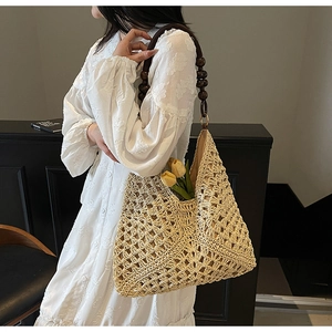Detail of hand-woven beige tote bag featuring vintage dark wood beaded handles and metal rings