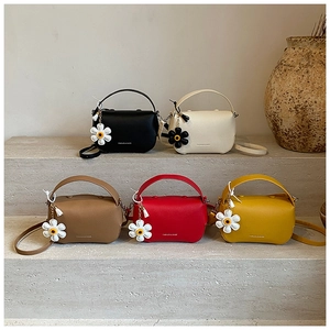 Group view of leather crossbody bags in five colors with floral daisy bag charms