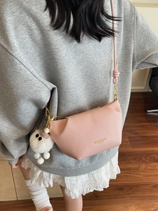 Sac bandoulière rose en cuir souple avec pendentif en peluche et design plissé