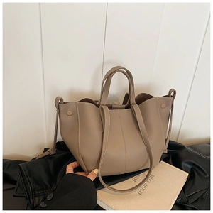 Close-up of the beige pebble leather tote bag texture and soft handheld strap