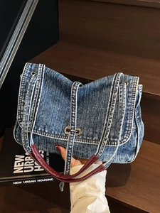 Sac cabas vintage en denim bleu avec anses en cuir bordeaux et fermoir en métal argenté