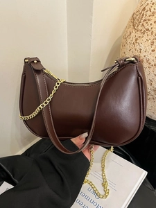 Deep brown half-moon underarm bag with matte leather texture and gold chain detail