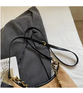 Détail du sac bandoulière matelassé kaki avec bordure noire et deux chaînes en métal