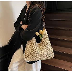 Detail of beige crochet tote bag with dark wooden bead straps and woven texture