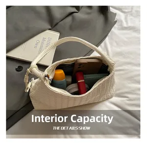 Detail showing internal capacity of white woven shoulder bag with daily essentials