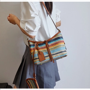 Detail of colorful striped straw bag with brown leather strap and small coin pouch