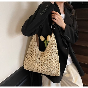 Close-up of beige woven tote bag with intricate knit texture and floral decoration