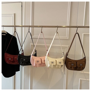 Detail view of crescent underarm bags with double front pockets and silver metal buckles
