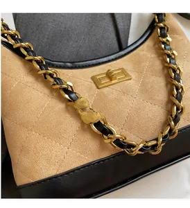 Détail de la chaîne dorée et de la texture en cuir matelassé sur le sac élégant