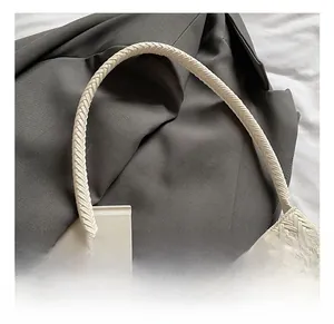 Detailed macro view of white woven handbag with cylindrical rope handle and fine texture