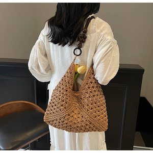 Detail of handwoven hobo shoulder bag with round wooden handles and beaded accents