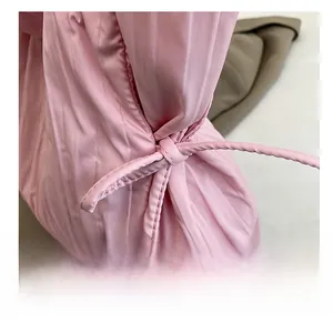 Dettaglio macro della borsa tote in tessuto rosa con trama a pieghe e cordino a nodo