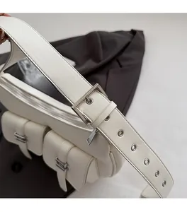 Detailed close-up of adjustable strap hardware and eyelets on off-white faux leather tote bag
